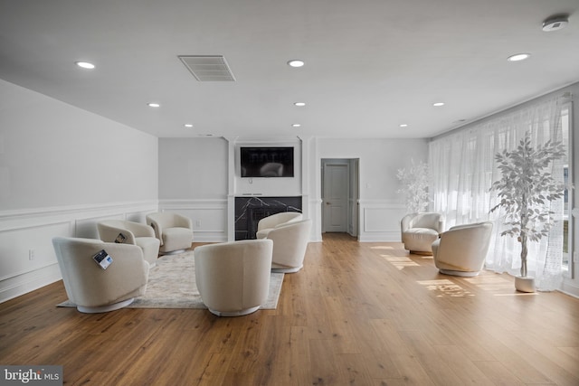 living room with a fireplace and light wood-type flooring