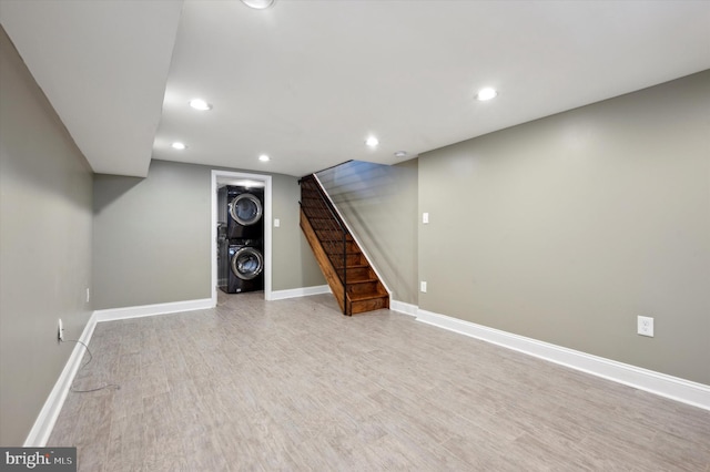 basement featuring light hardwood / wood-style floors and stacked washer and dryer