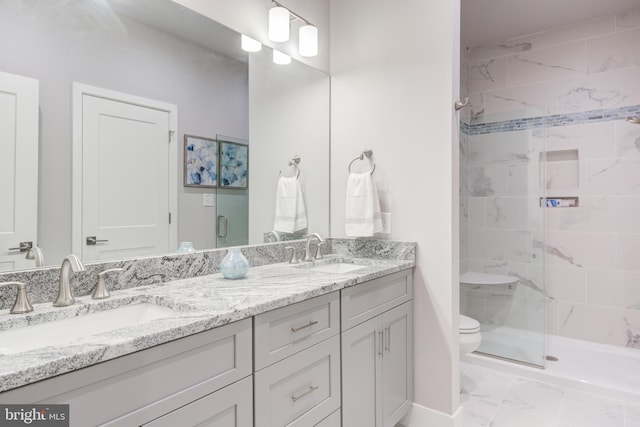 bathroom featuring vanity, toilet, and a shower with door