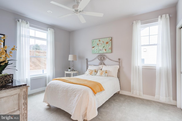 carpeted bedroom with ceiling fan and multiple windows