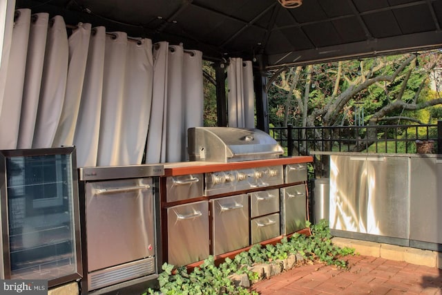 view of patio with a gazebo, exterior kitchen, and beverage cooler