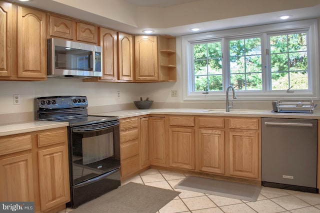 kitchen with light tile patterned floors, stainless steel appliances, and sink