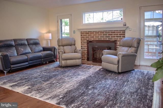 living room featuring a brick fireplace and hardwood / wood-style floors