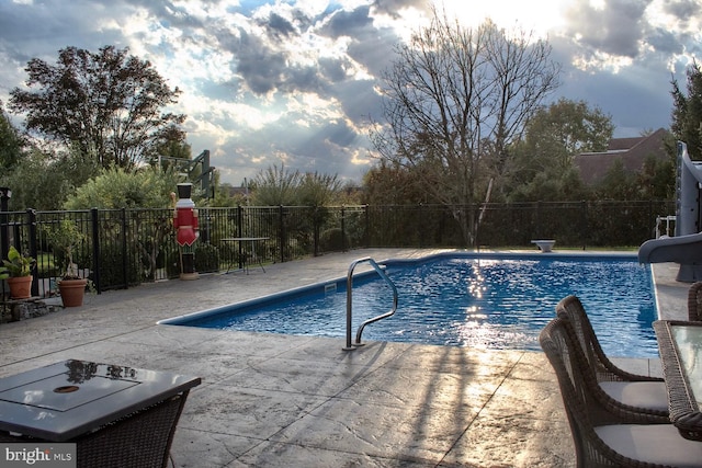 view of swimming pool featuring a water slide and a patio area