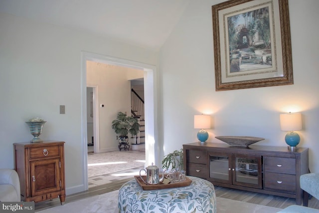 sitting room featuring light wood-type flooring and vaulted ceiling