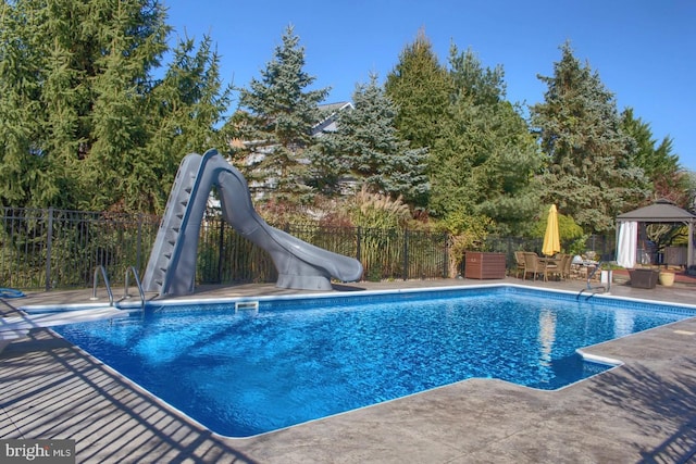 view of pool with a gazebo, a water slide, and a patio