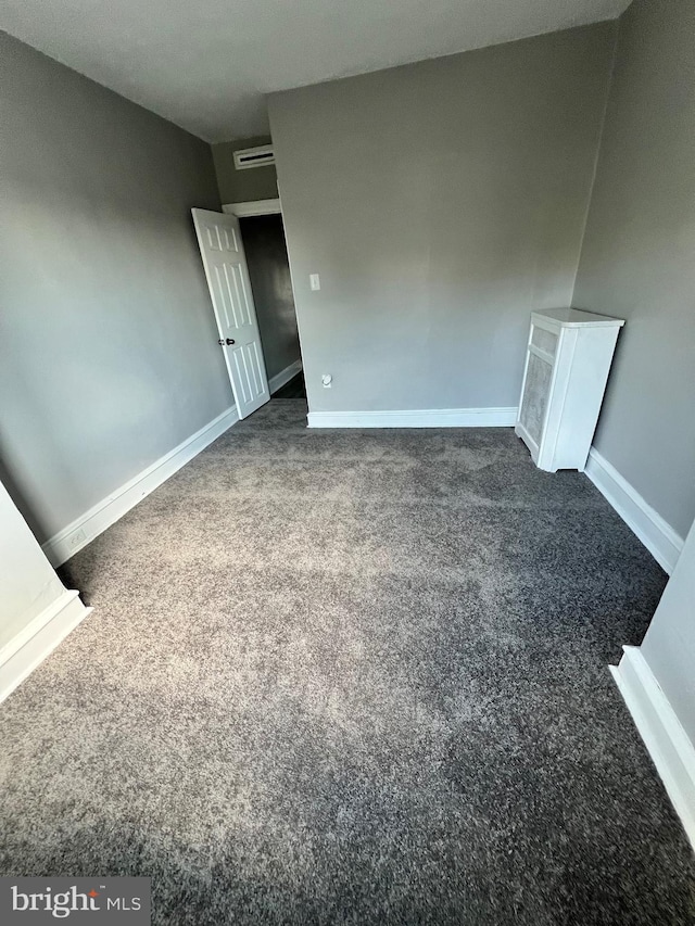 empty room featuring dark carpet