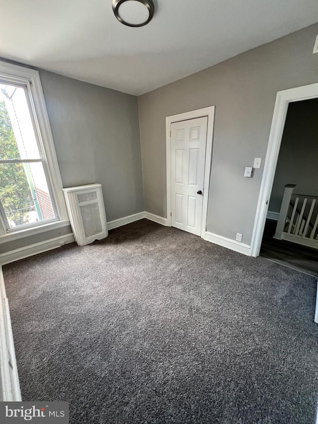 unfurnished bedroom featuring dark carpet