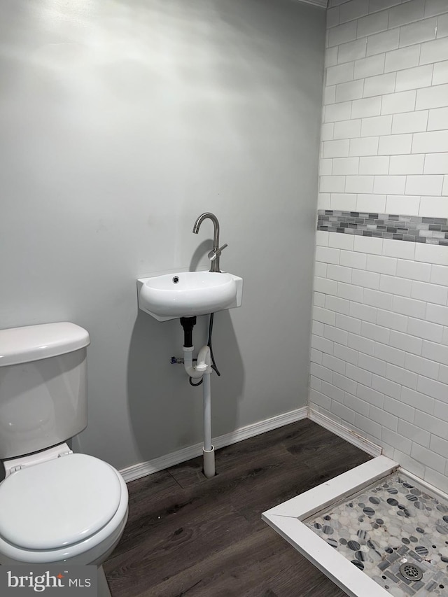 bathroom featuring walk in shower, toilet, sink, and hardwood / wood-style floors