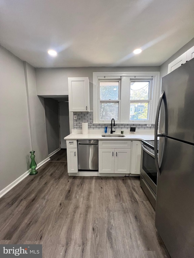 kitchen featuring stainless steel appliances, dark hardwood / wood-style floors, sink, and white cabinetry