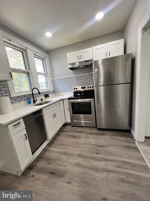 kitchen featuring wood-type flooring, white cabinets, and appliances with stainless steel finishes