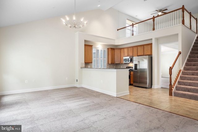 kitchen featuring high vaulted ceiling, appliances with stainless steel finishes, light carpet, and a healthy amount of sunlight