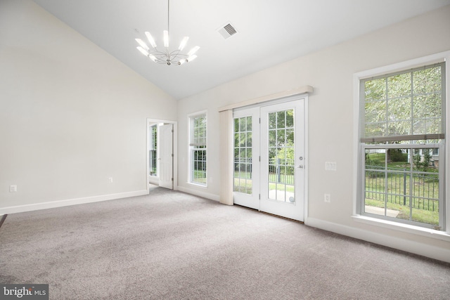 empty room with a chandelier, light carpet, and high vaulted ceiling