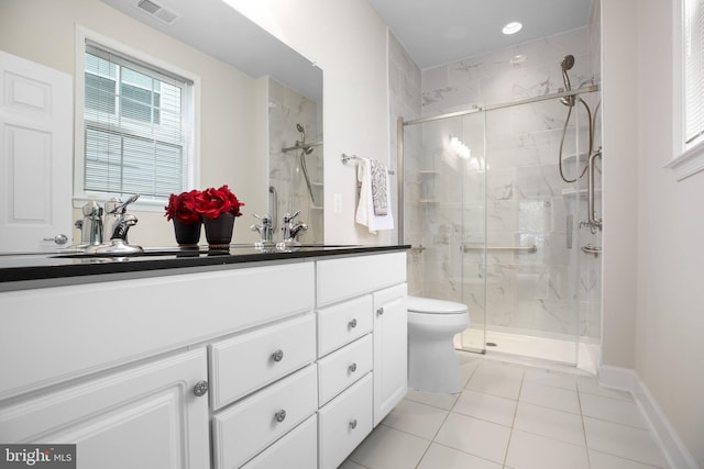 bathroom featuring vanity, a shower with shower door, tile patterned flooring, and toilet