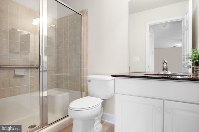 bathroom with a shower with shower door, vanity, and toilet