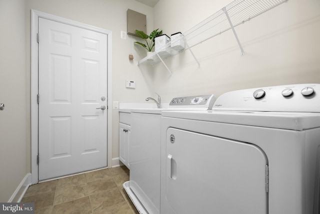 laundry room featuring washer and clothes dryer and cabinets