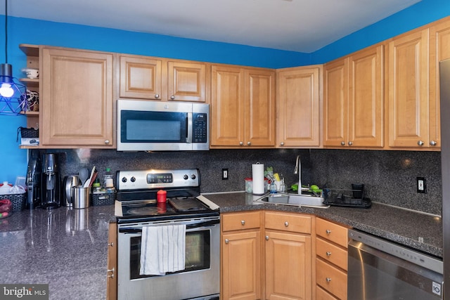 kitchen with appliances with stainless steel finishes, sink, and decorative backsplash