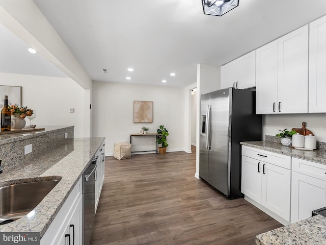 kitchen with white cabinetry, dark wood-type flooring, and light stone counters