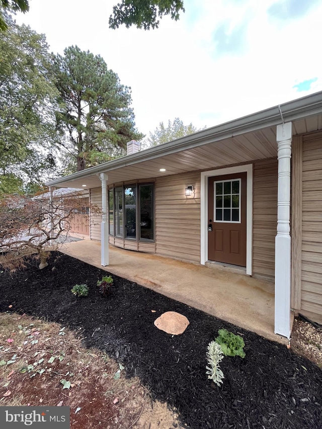 view of exterior entry featuring a patio area