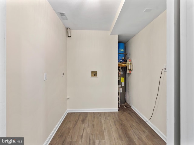 laundry room with hardwood / wood-style floors, hookup for a washing machine, and water heater