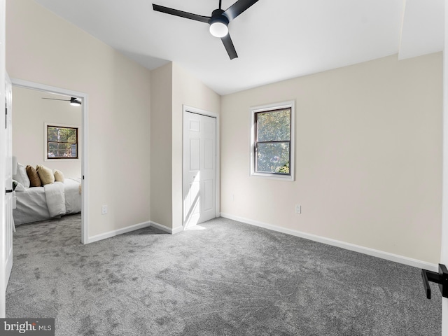 unfurnished bedroom with carpet, ceiling fan, and vaulted ceiling