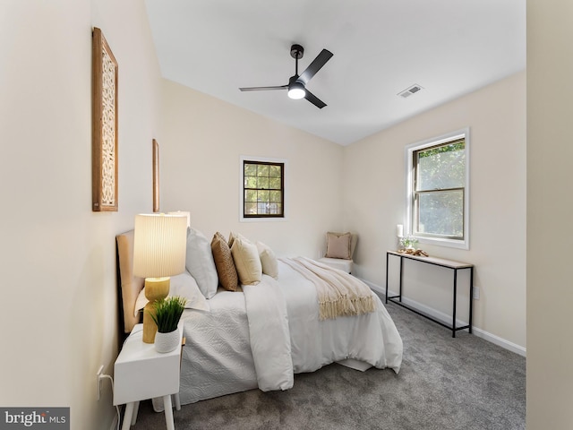 carpeted bedroom with ceiling fan, vaulted ceiling, and multiple windows