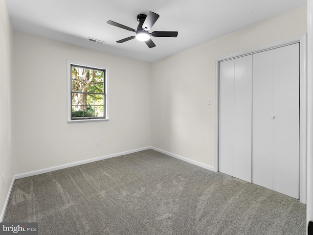 unfurnished bedroom featuring ceiling fan, a closet, and carpet floors