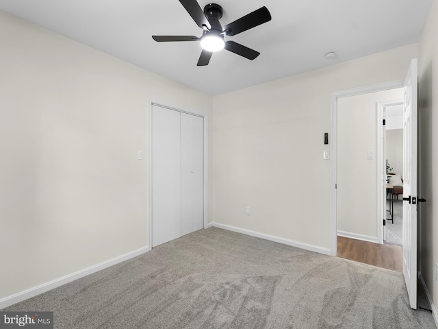 unfurnished bedroom with ceiling fan, light carpet, and a closet