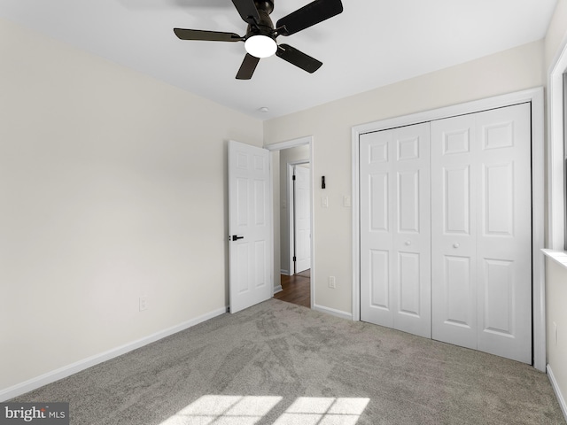 unfurnished bedroom featuring ceiling fan, light colored carpet, and a closet