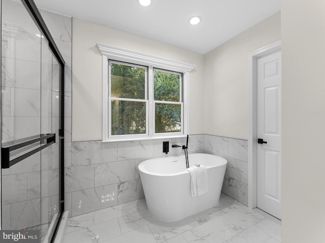 bathroom featuring separate shower and tub and tile walls