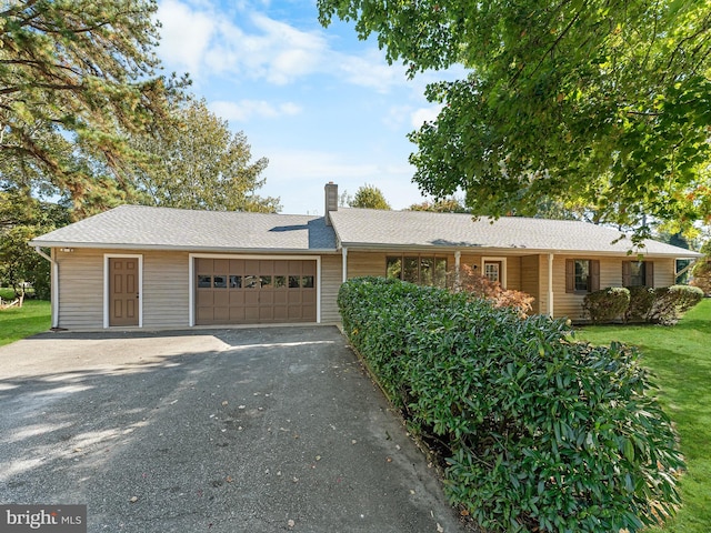 ranch-style house with a garage and a front lawn