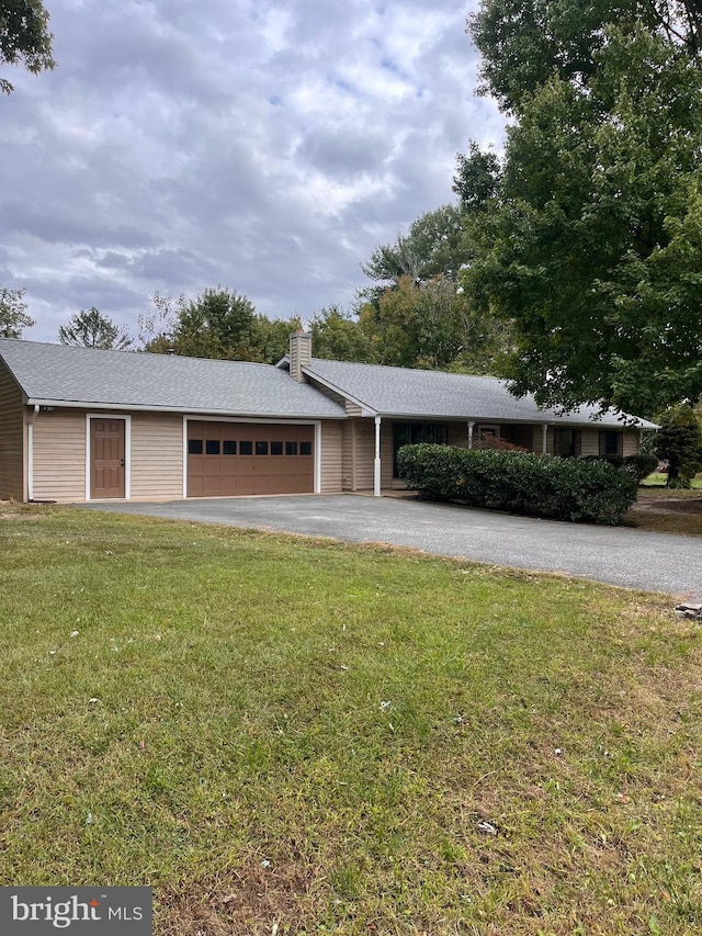 ranch-style house featuring a garage and a front lawn