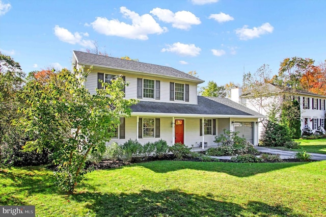 view of front of house with a garage, a front yard, and covered porch