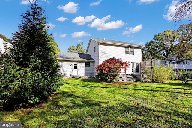 rear view of house with a deck and a lawn