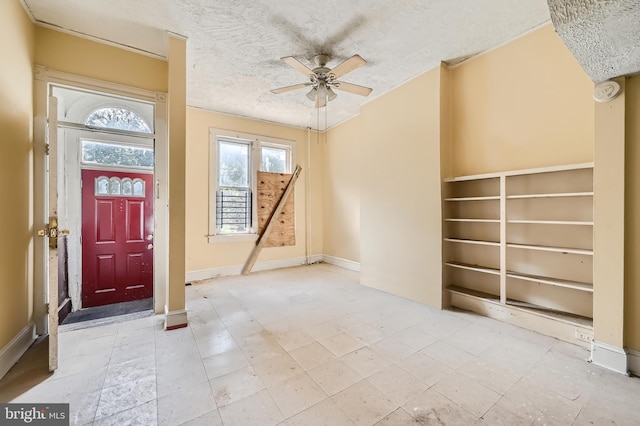 foyer entrance with a textured ceiling and ceiling fan