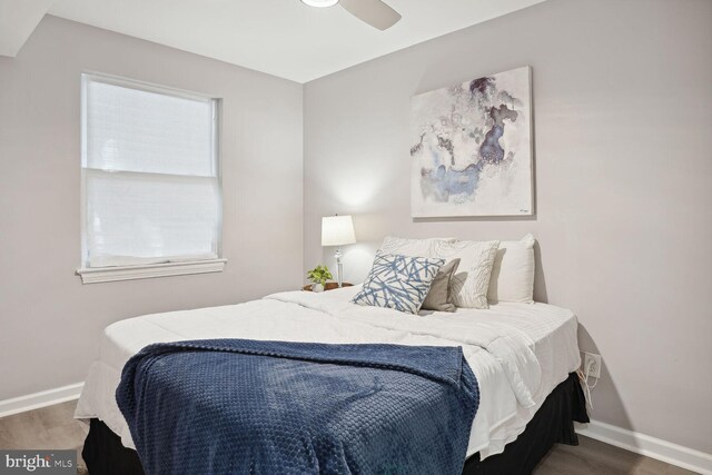 bedroom featuring multiple windows, hardwood / wood-style floors, and ceiling fan