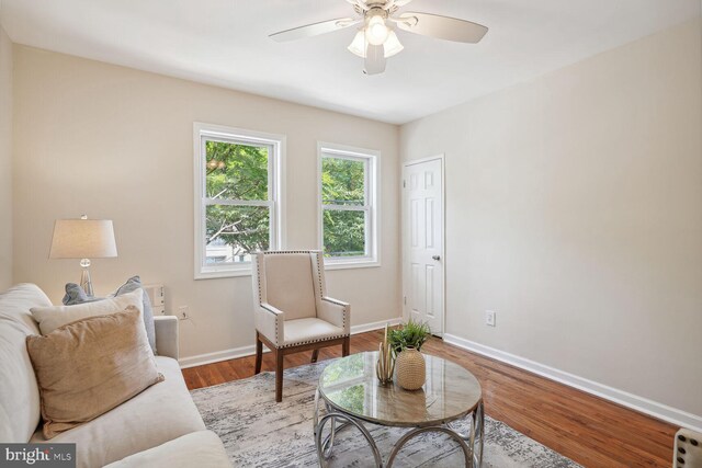 living room featuring light hardwood / wood-style flooring and ceiling fan