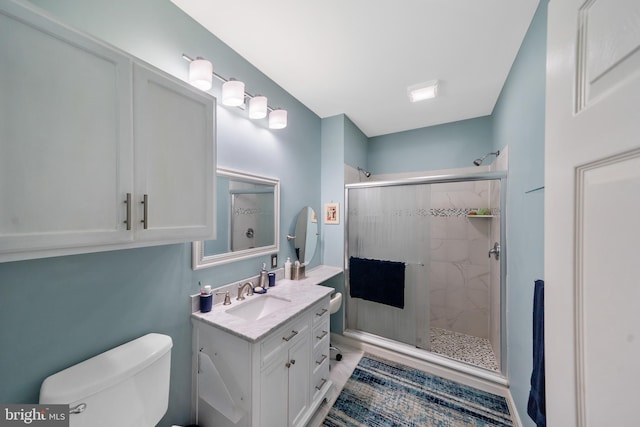 bathroom featuring toilet, an enclosed shower, and vanity