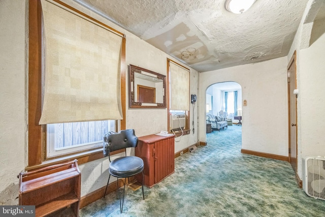 hall featuring cooling unit, carpet, and a textured ceiling