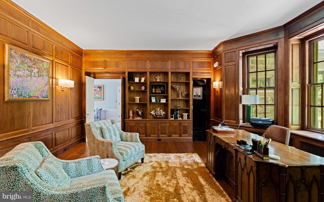 sitting room with ornamental molding, dark hardwood / wood-style floors, and wood walls