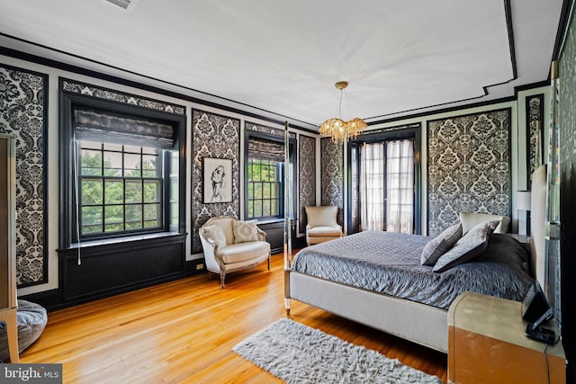 bedroom featuring ornamental molding, a chandelier, and hardwood / wood-style floors