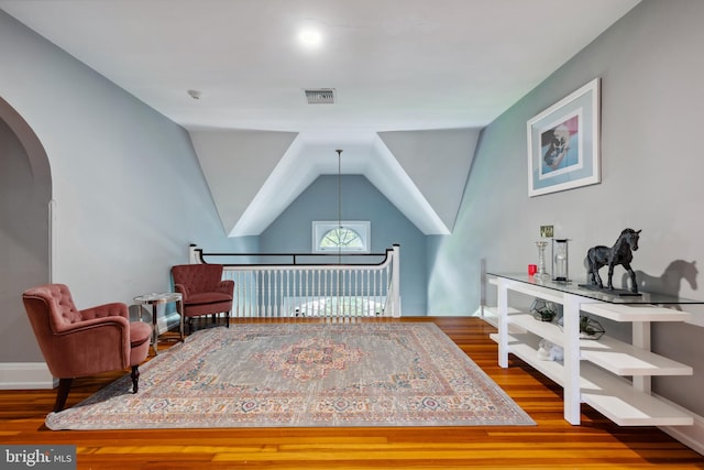 living area with hardwood / wood-style floors and vaulted ceiling