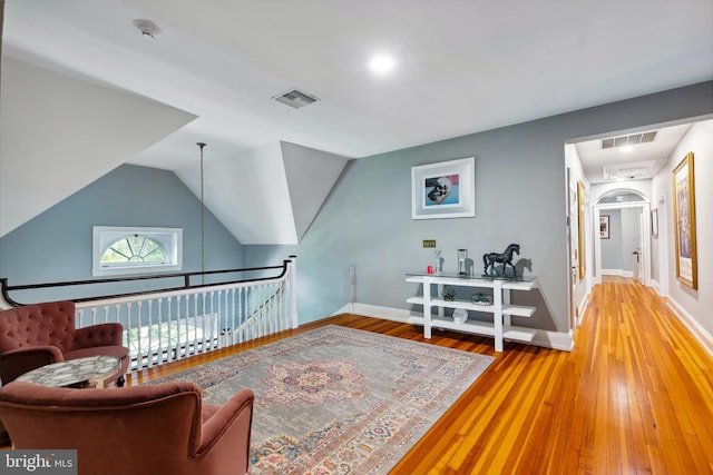 living area featuring vaulted ceiling and hardwood / wood-style floors