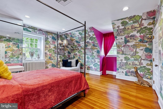 bedroom with radiator heating unit and hardwood / wood-style floors