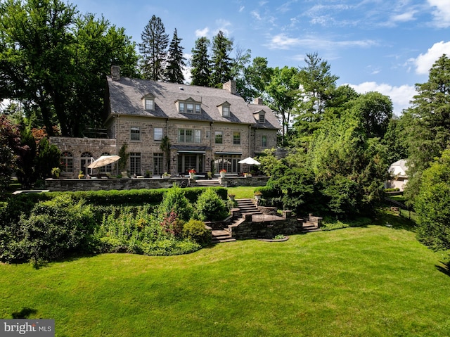 rear view of property with a lawn and a patio