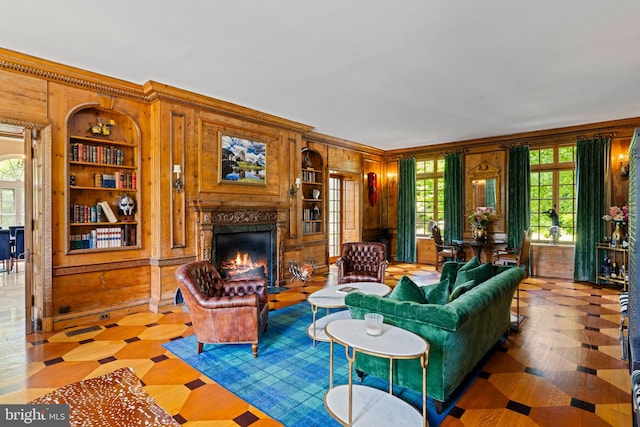 living room with crown molding, built in features, and wood walls