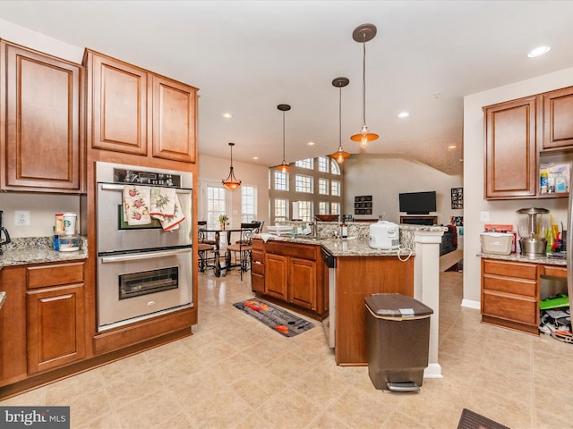 kitchen with stainless steel appliances, light stone counters, lofted ceiling, decorative light fixtures, and a center island with sink