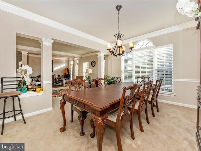 dining space featuring ornate columns, light carpet, ornamental molding, and an inviting chandelier