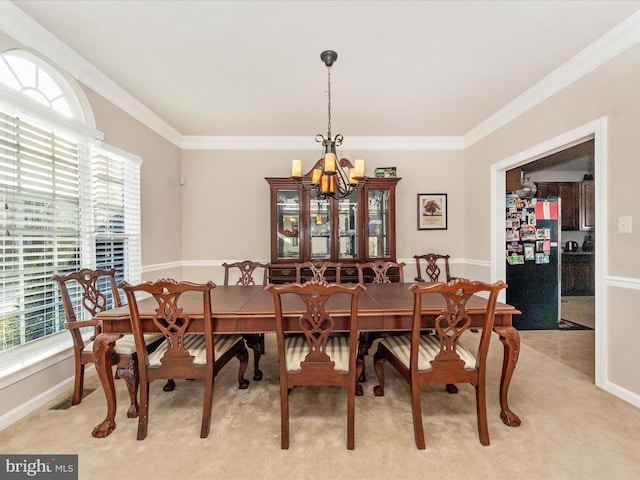 carpeted dining room with crown molding, a healthy amount of sunlight, and an inviting chandelier