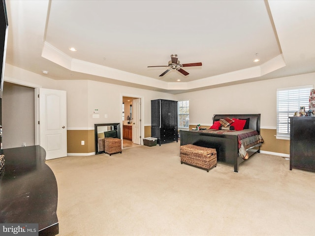 bedroom with a tray ceiling, ceiling fan, crown molding, and light colored carpet